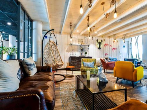 a living room with a couch and a table at ibis styles La Rochelle Thalasso Chatelaillon in Châtelaillon-Plage