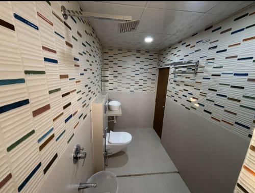浦那Sunrise Comfort Rooms - International Tech Park Kharadi Highway的浴室设有卫生间和瓷砖墙