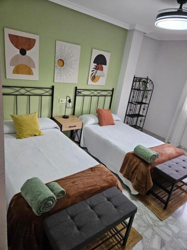 zwei Betten in einem Zimmer mit grünen Wänden in der Unterkunft MEQUEDO Casa Alicia in Alcañiz