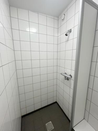 a bathroom with a shower with white tiled walls at Smart-Stay-Padborg in Padborg