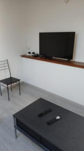 卡莱帕涅T2 refait à Neuf au calme avec TV et Fibre的客厅配有桌子、电视和椅子