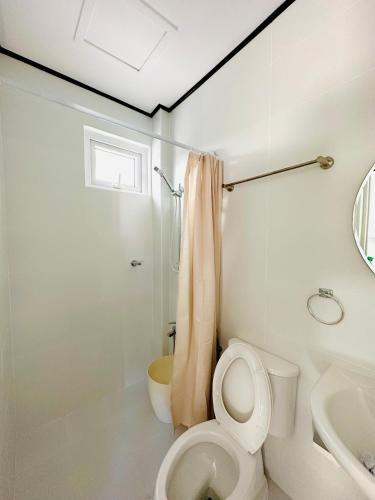 a white bathroom with a toilet and a sink at Casa VLOM Staycation in Roxas City