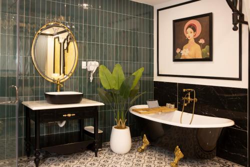 a bathroom with a sink and a mirror and a tub at Love Luxury Hotel Vườn Lài in Ho Chi Minh City