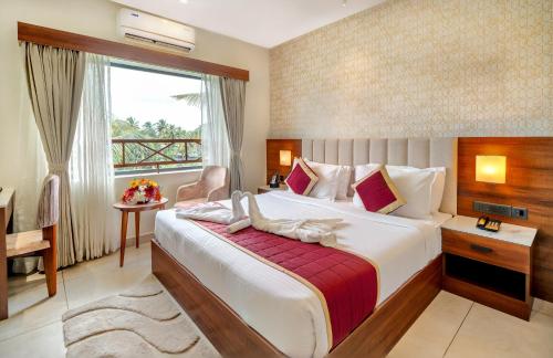 a hotel room with a large bed and a window at PASSIONS HOTEL EDATHUA - Alappuzha in Champakulam