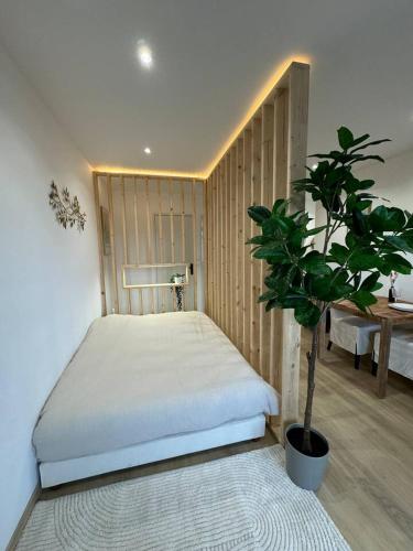 a bedroom with a bed and a potted plant at L'échappée Alsacienne - Studio in Saint-Louis in Saint-Louis