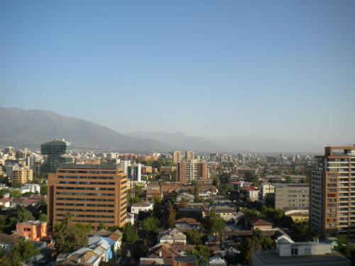 a city with buildings and mountains in the background at Barceló Suites Providencia I in Santiago