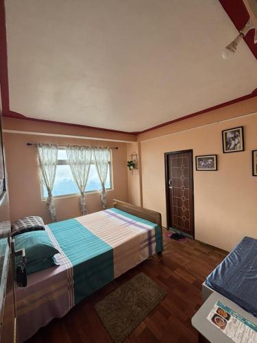 a bedroom with a large bed with a window at V V Homestay in Darjeeling