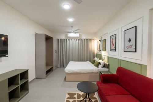 Un dormitorio con una cama y un sofá rojo. en House of KP by Union, en Pune