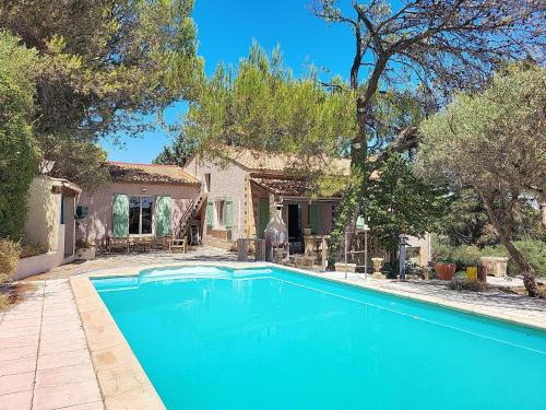 Maison Aramon في Aramon: حمام سباحة أزرق أمام منزل