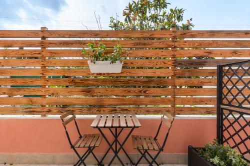 uma cerca de madeira com uma mesa e duas cadeiras em Villa Giavitto em Fiumicino