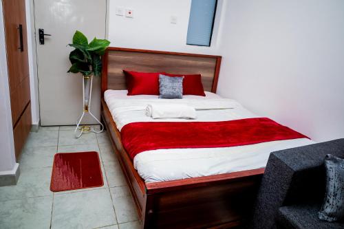 a bedroom with a large bed with red pillows at Studio in Roysambu with a study desk in Nairobi
