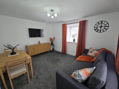a living room with a couch and a table at Data House Apartments ONE in Atherstone