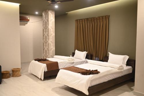 a bedroom with two beds and a window at Oak House in Dimāpur