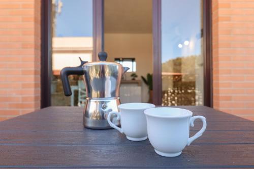 una macchinetta del caffè e due tazze su un tavolo di Masi House a La Massimina-Casal Lumbroso