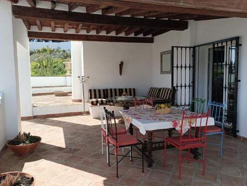 a dining room with a table and chairs on a patio at villa el almendro in Carratraca