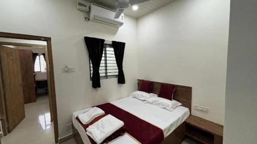 Schlafzimmer mit einem Bett und einem Fenster in der Unterkunft Port Inn Lodge in Mangaluru