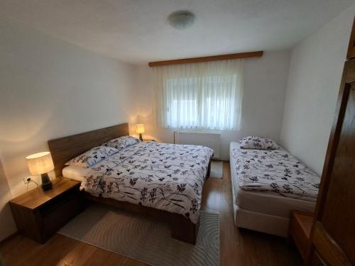 a small bedroom with two beds and a window at Jakiland house Plitvice Lakes in Korenica