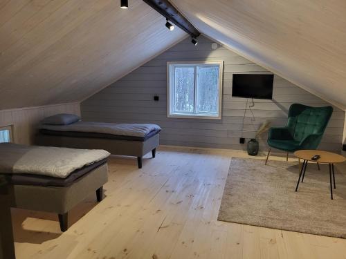 a attic room with two beds and a television at Villa Hattara - a cottage on the shore of a rapid in Nukari