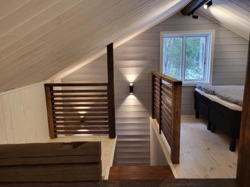 a staircase in a tiny house with a bed and a window at Villa Hattara - a cottage on the shore of a rapid in Nukari
