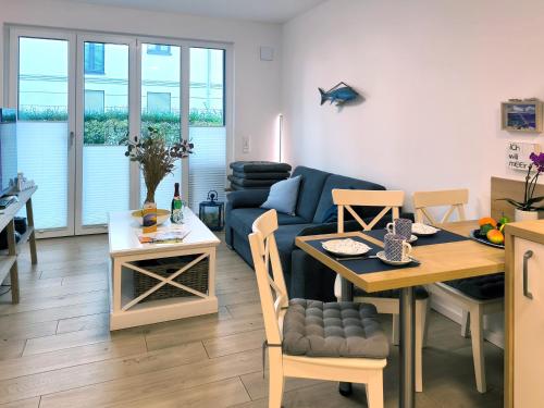 a living room with a table and a blue couch at Baabe Villen-Ensemble FeWo 41 Muschelsucher in Baabe