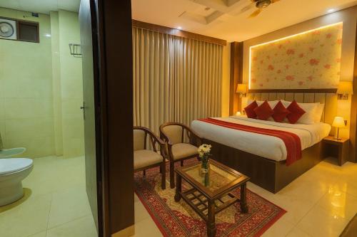 um quarto de hotel com uma cama e um banheiro em Hotel Ramawati, A Luxury Hotel & Resort, Haridwar em Haridwār