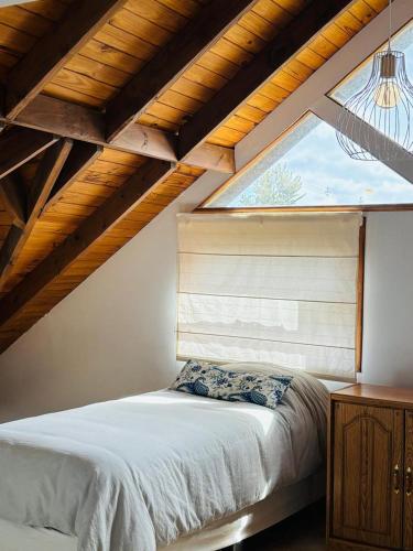 a bedroom with a bed in a room with a window at Las Margaritas in Ushuaia