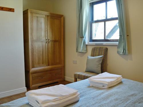a bedroom with a bed with two white towels on it at Hindscarth in Keswick