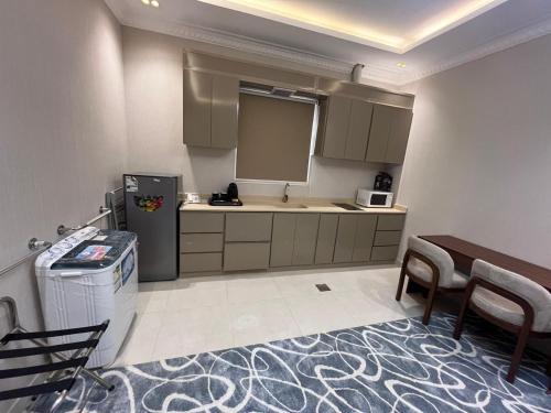a kitchen with a refrigerator and a table and chairs at العييري ريزيدنس in Dammam