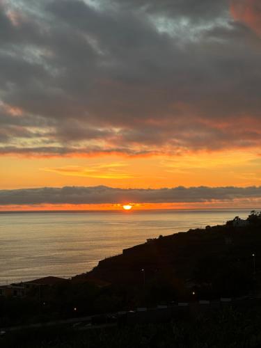 a sunset over the water with the sun in the sky at Madeira Mar - "Seaside" in Funchal