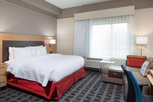 ein Hotelzimmer mit großem Bett und Schreibtisch in der Unterkunft TownePlace Suites by Marriott Swedesboro Logan Township in Swedesboro
