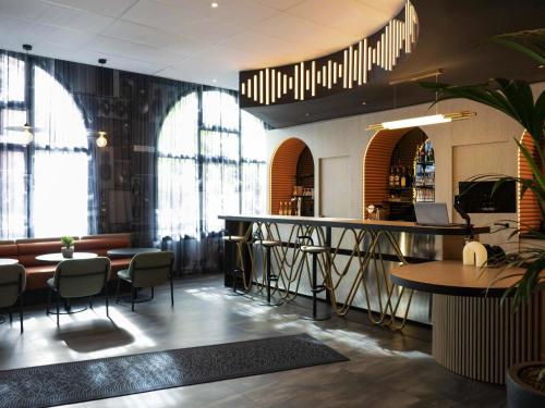 伊西莱穆利诺ibis Styles Paris Porte de Versailles - Mairie d'Issy的有酒吧和桌椅的餐厅