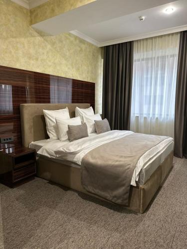 une chambre avec un grand lit dans une pièce dans l'établissement Nord Gate Avenue Hotel, à Erevan