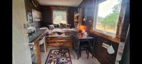 a room with a bed and a desk and a window at Hjortebu i naturskjønne omgivelser in Åseral