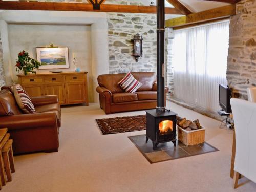 a living room with a wood stove in a room at Penno Cottage - 24440 in Bodmin