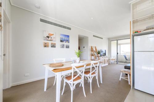 a kitchen with a table and chairs and a refrigerator at Sanny Side Up in San Remo