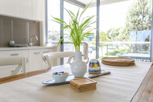 a table with a vase with a plant on it at Sanny Side Up in San Remo