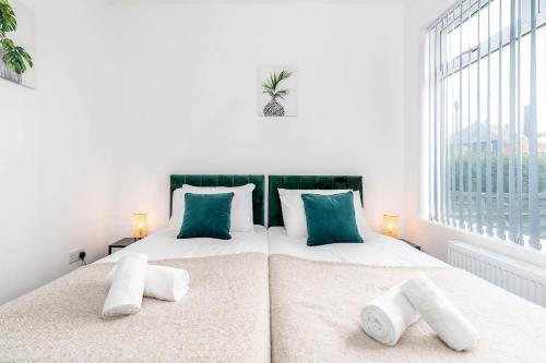 a bedroom with two beds and a large window at 4 Bedroom House with 2 Bathrooms - Back Garden with Outdoor Seating Sleeps 7 in Heeley