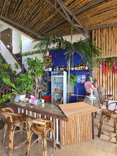 Habitación con mesa, sillas y nevera. en Islandfront El Nido, en El Nido