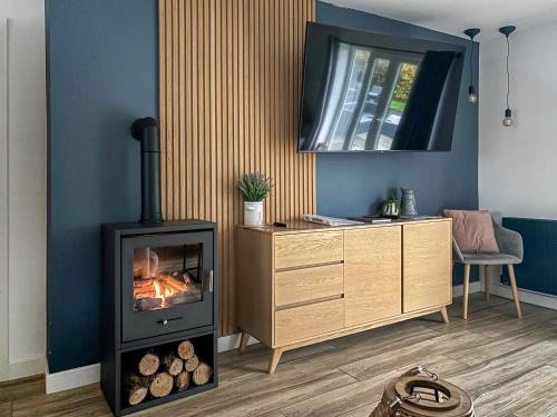 a living room with a wood stove and a dresser at Cefn Gelli in Clynderwen