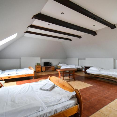 a room with two beds and two tables at Zajazd Pasja in Sławków