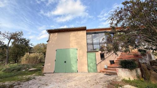 TaulignanProvençal Getaway Pool Studio Hiking的田野里有一扇绿色门的房子