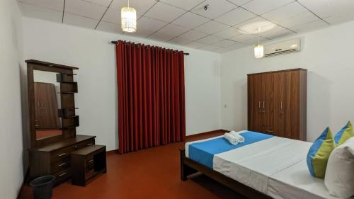 a bedroom with a bed and a red curtain at MPR villa in Tangalle