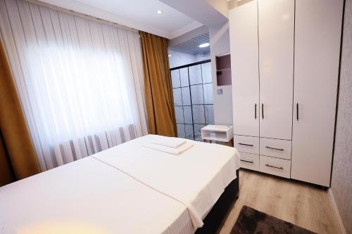 ein Schlafzimmer mit einem weißen Bett und einem Fenster in der Unterkunft Casa Florya Suites in Istanbul