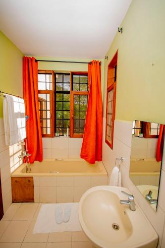 a bathroom with a tub and a sink at Amani Farmhouse in Usa River