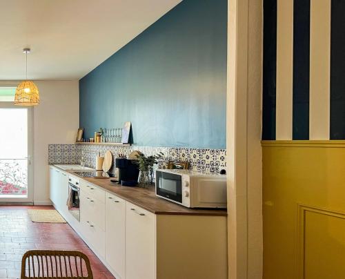 a kitchen with a counter with a microwave on it at Le Sicile -Appartement agréable à Lespignan in Lespignan