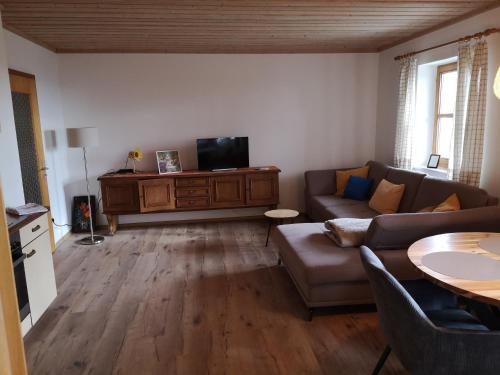 a living room with a couch and a flat screen tv at Appartement Panoramablick in Grattersdorf