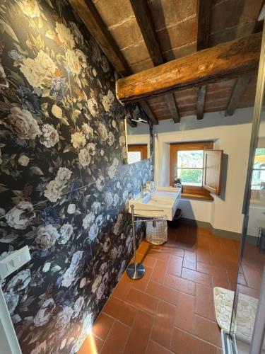 a bathroom with a floral mural on the wall at La Mora Affittacamere in Tuoro sul Trasimeno
