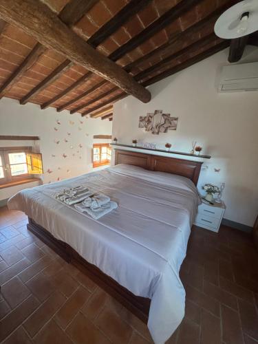 a large bed in a bedroom with wooden ceilings at La Mora Affittacamere in Tuoro sul Trasimeno