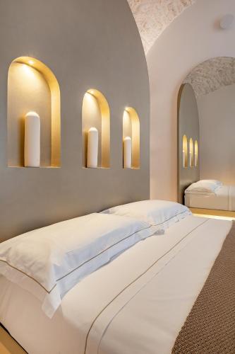 een slaapkamer met twee bedden en drie spiegels bij Casalis Luxury Room in Ostuni