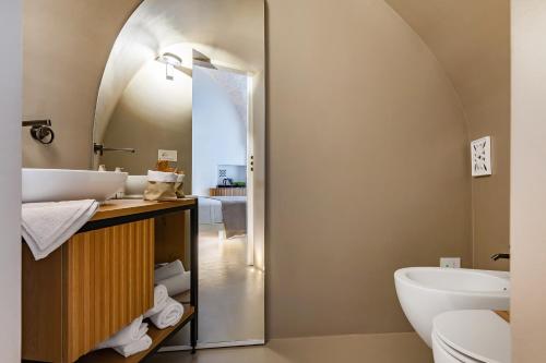 een badkamer met een wastafel en een toilet bij Casalis Luxury Room in Ostuni